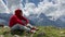 Adult male in red hoodie with hood enjoying beautiful view in mountainous area.