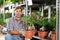 Adult male salesman with pot of ficus in plant store