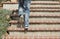 Adult male walking up cement tiled stairs