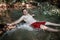 Adult man baths in stream river in mountains, natural pool and spa. Cold water, active green tourism