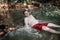 Adult man baths in stream river in mountains, natural pool and spa. Cold water, active green tourism