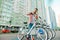 An adult man with a beard and a red shirt takes a sharing bike for a walk around town. Travel around the city on a rented city