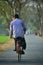 Adult man is bicycling on a vacant road stock photograph