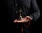 Adult man in a black shirt holds a copper Tibetan ritual bell, low key