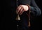 Adult man in a black shirt holds a copper Tibetan ritual bell, low key