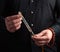 Adult man in a black shirt holds a crystal chakra rod inlaid with semiprecious stones