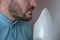 An adult man breathes steam, treats the airways with a nebulizer at home.