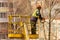 An adult man with a chainsaw in his hands cuts branches off an old tree.