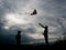 Adult man and child launch a kite against a beautiful summer sunset