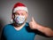 Adult man in Christmas decorated mask, Gesturing Thumbs Up.