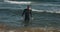 Adult man in diver suit swimming in the sea. Cute young man swimmer diving into the sea wave. Tall guy with beard