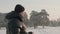 Adult man drinking hot tea on snowy forest landscape at copy space at winter day