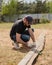 An adult man is engaged in carpentry work at a house construction site