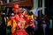 Adult man in flamboyant costume walks by city street on dominican carnival