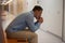 Adult man leaning on hands sits on couch in clinic