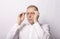 Adult man putting on glasses. Businessman wearing eyewear on white background