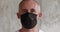 Adult man in quarantine removes black medical mask