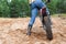 Adult man riding on sandy dirt track with his motorcross motorcycle, rear view, copyspace