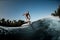 adult man riding on the wave with hydrofoil foilboard on background of blue sky