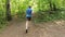 Adult man running jogging outdoors in a forest nature on a forest trail and enjoying it and looking happy