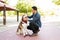 Adult man scratching a dog`s head at the park