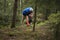 Adult man volunteer in red gloves removes plastic trash in forest, caring for environment