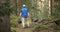 Adult man volunteer in red gloves removes plastic trash in forest, caring for environment