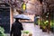 An adult man walked down the street of a city with a black umbrella on a rainy day