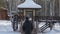 Adult man walking on decorative bridge in winter city park back view