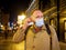 Adult man wearing mask walking in a night european city