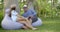 Adult man and woman are communicating and talking to each other sitting in tropical park in daytime
