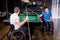 Adult men with disabilities in a wheelchair play billiards in the club