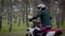 An adult motorcycle driver drives through the forest more often in the daytime, a man wore a protective helmet over his