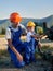 Adult oil worker and little boy in work uniform near pipeline.