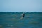 Adult person kitesurfing on the water waves in on a sunny day