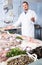 Adult polite man standing near fish counter