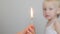 Adult`s hand holding a burning match in the background portrait of a child, fire, concept, close-up, copy-space, white