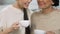 Adult sisters smiling and talking with tea cups, home relax atmosphere, support