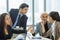 Adult smart diverse Caucasian businesspeople wearing formal suit, taking break, smiling, working, meeting, discussing and relax