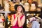 Adult smiling woman try on boater hat in shopping mall