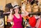 Adult smiling woman try on boater hat in shopping mall