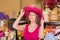 adult smiling woman try on pink boater hat in shopping mall