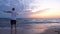 Adult sportsman warming up arms on seashore in the morning