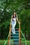 Adult or teenager girl having fun on children playground. Urban teen girl with brunette long hair posing on playground park.