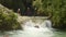 Adult tourist man doing canyoning throwing himself into a waterfall