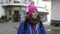 adult tourist woman with backpack is walking in small city at winter day, portrait