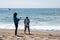 Adult tourists fuss and play with their phones while enjoying the sunshine at Point Dume