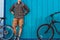 Adult Traveler Man Stands With A Bicycles Near Blue Wall Daily Lifestyle Urban Resting Concept