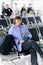 Adult traveler woman with carry-on baggage, backpack and passport awaits boarding a flight for departure, online check