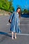 Adult woman in blue dress and straw hat walking near the river. Fortieth people